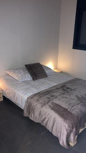 - un lit dans une chambre avec une couverture dans l'établissement F2 Ti amo 1 chambre, à Saint-Germain-lès-Corbeil