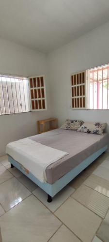 a large bed in a room with a white room at Mini Recanto da Rosalina in Prado