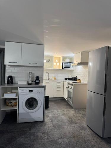 une cuisine avec un lave-linge et un réfrigérateur dans l'établissement Osiris, à Argenteuil