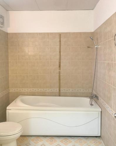 a bathroom with a white tub and a toilet at A L Y S S A Seaside Muine in Mui Ne