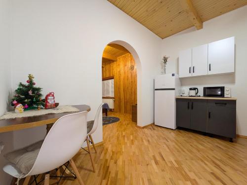 a kitchen and living room with a table and a christmas tree at Солодка Мить in Slavske