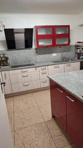 a kitchen with red cabinets and a counter top at Maison entière - entire house in Differdange