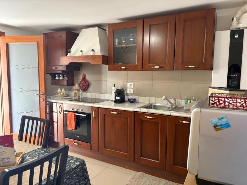 a kitchen with wooden cabinets and a white refrigerator at La casa di Chicca in Noventa Padovana