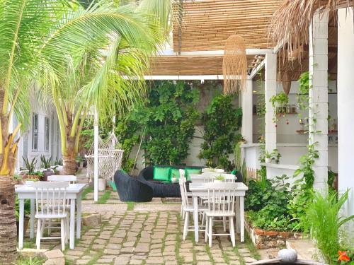 a patio with tables and chairs and a couch at A L Y S S A Seaside Muine in Mui Ne