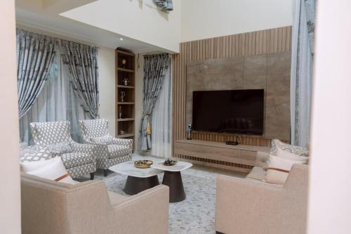 a living room with two chairs and a television at Urban Elite Stay in North Legon
