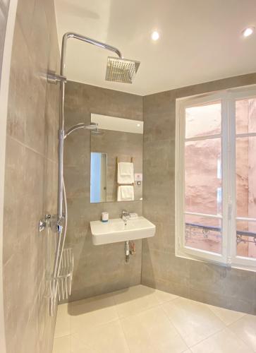 une salle de bain avec un lavabo et une douche dans l'établissement Charm & Comfort Apartment - Heart of Montmartre, à Paris