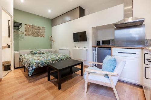 Cette petite chambre comprend un lit, une table et une chaise. dans l'établissement Superbe studio proche d'Orly et de Massy, à Longjumeau