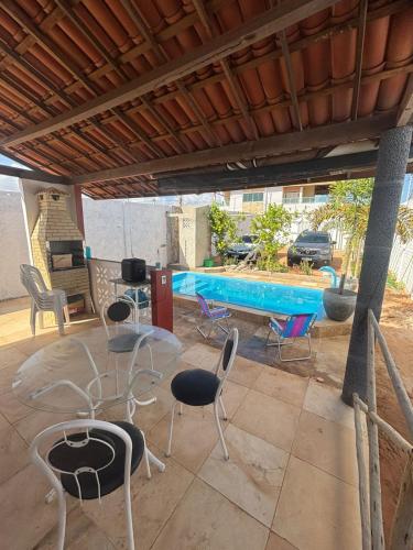 a patio with chairs and a swimming pool at Refúgio da Major in Aracati