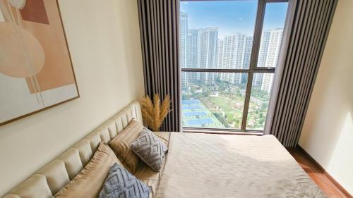 a bed in a room with a large window at Ocean apartment in Gia Lâm Pho