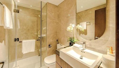 a bathroom with a sink and a toilet and a mirror at Ocean apartment in Gia Lâm Pho