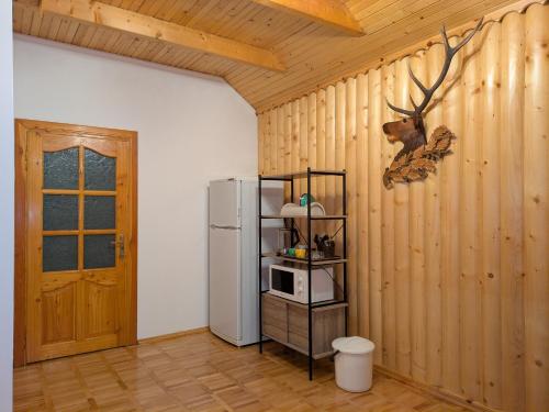 a kitchen with a refrigerator and a shelf with a microwave at Солодка Мить in Slavske