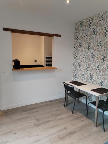 une table et des chaises dans une pièce avec un mur dans l'établissement Campagne à côté de Paris, à Romainville