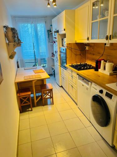 une cuisine avec une table et une machine à laver dans l'établissement Le Confort Urbain, à Chevilly-Larue