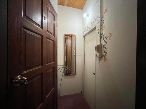 a hallway with a door and a plant in it at Once in Lampang Guesthouse in Lampang