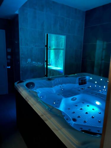 La salle de bains bleue est pourvue d'une baignoire et d'une fenêtre. dans l'établissement Le Golden Spa, à Montpellier