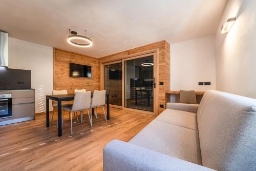 a living room with a table and chairs at Appartamenti Ai Due Campanili in Pellizzano