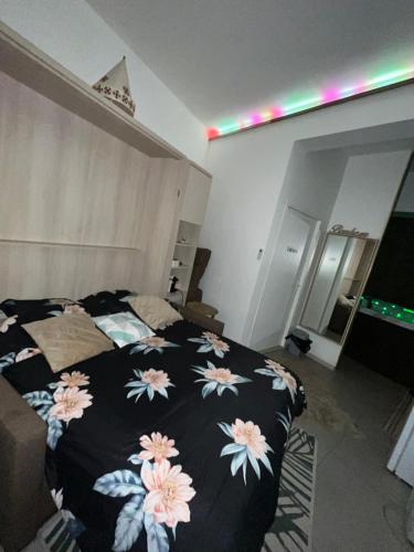 - une chambre avec un lit et une couverture noire fleurie dans l'établissement Le Golden Spa, à Montpellier