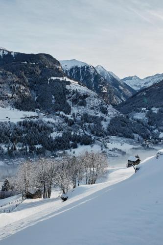 a bench in the snow with mountains in the background at Haus Talblick in Bad Gastein
