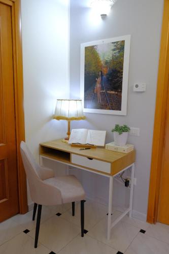 a desk with a lamp and a chair and a painting at La Residenza del Marchesato in Marano Marchesato