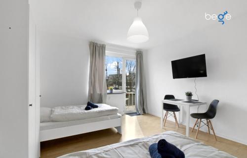 a bedroom with a bed and a desk and a tv at BEGE APARTMENTS: FIRM RELAX in Mettmann