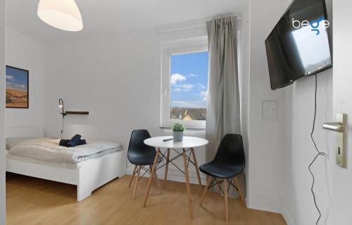 a small room with a bed and a table and chairs at BEGE APARTMENTS: FIRM RELAX in Mettmann