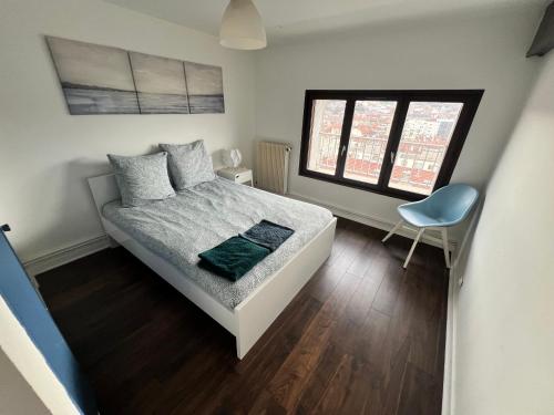 une petite chambre avec un lit et une chaise dans l'établissement 014 CHIC & COSY GRAND APPART DUPLEX 76m2 WIFI SMART TV NETFLIX ET VUE PANORAMIQUE, à Saint-Étienne