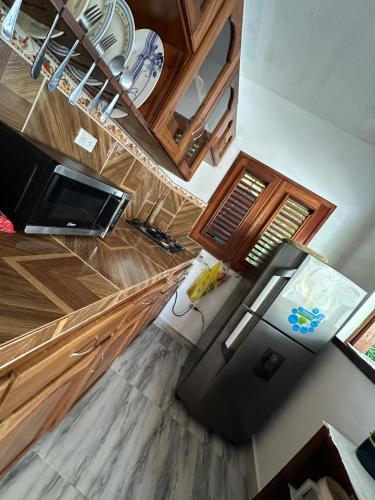 a kitchen with a black refrigerator and wooden cabinets at Casa Mariana in Las Terrenas