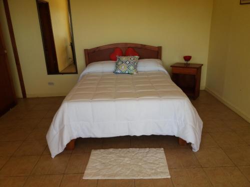 a bedroom with a large bed with a pillow on it at La Princesa Hotel in San Isidro