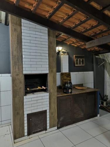 a kitchen with a counter and a brick wall at Casa Pé Na areia in Piçarras
