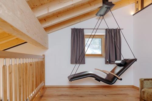 a black chair hanging from the ceiling in a living room at Biobauernhof Obermühle in Mittersill