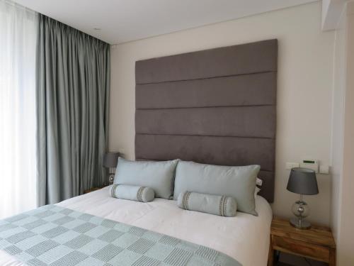 a bedroom with a large white bed with two pillows at 202 Kylemore A Waterfront Marina in Cape Town