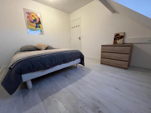 a bedroom with a bed and a dresser at Family Disney coconing à 10 minutes du Parc in Coupvray