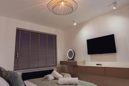 a living room with a flat screen tv on the wall at Newly renovated house in Canterbury