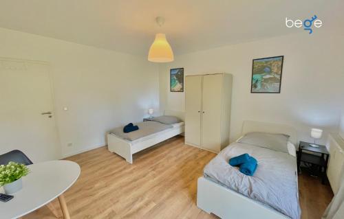 a bedroom with a bed and a table in it at BEGE APARTMENTS: FIRM RELAX in Mettmann