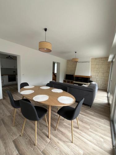 a living room with a table and chairs and a couch at Family Disney coconing à 10 minutes du Parc in Coupvray
