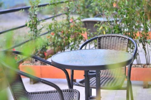 a table and chairs sitting on a balcony at Monteverde Best Inn - HOTEL in Tenza