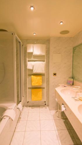 クックスハーフェンにあるSeeschlößchen - Hotel Strandperleの浴槽、洗面台、シャワーを備えたバスルーム