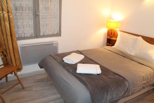 une chambre avec un lit avec deux serviettes dessus dans l'établissement Charmant T2 au pied de la Cité, à Carcassonne