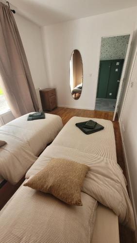 deux lits dans une chambre avec un miroir dans l'établissement Parenthèse en Terre Breizh, à Bohal
