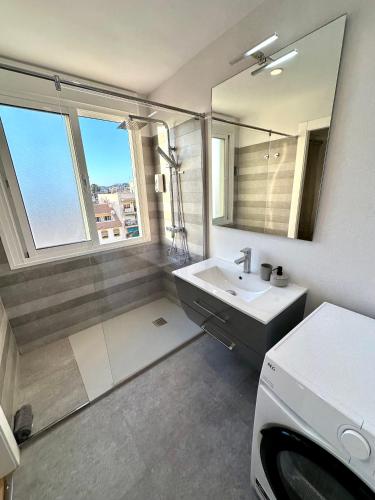 a bathroom with a sink and a large mirror at Horizonte 3 Charming apartment with breathtaking sea view at first line of Fuengirola beach in Fuengirola