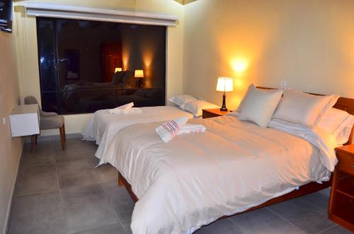 a bedroom with two beds and a window at Monteverde Best Inn - HOTEL in Tenza