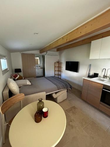 une chambre d'hôtel avec un lit, une table et une cuisine dans l'établissement Cosy Studio Fréjus Centre Historique, à Fréjus