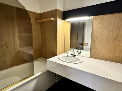 une salle de bain avec un lavabo, un miroir et une baignoire dans l'établissement Résidence Le Tourmalet - maeva Home - Studio 4 personnes - Confort MAE-0401, à La Mongie