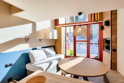 un salon avec un canapé et une table dans l'établissement Résidences quartier Charmettoger - maeva Home - Appartement avec balcon vue montagne 2 pièces 4 personnes - Prestige - super Home MAE-3511, à Arc 1800