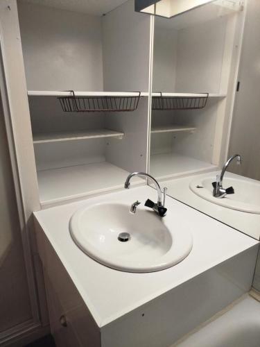 une salle de bain avec un lavabo blanc et un miroir dans l'établissement Résidence Le Tourmalet - maeva Home - Studio 4 personnes - Confort MAE-7961, à La Mongie