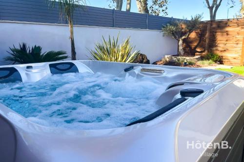 d'un bain à remous avec de l'eau bleue dans l'arrière-cour dans l'établissement L'Olivier - Private Spa and Garden, à Mèze