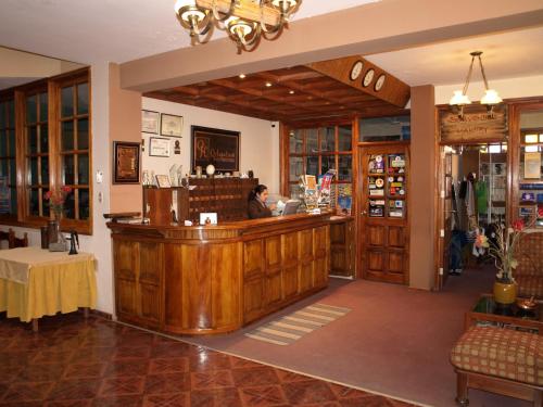 a woman sitting at a bar in a store at Qelqatani Hotel in Puno