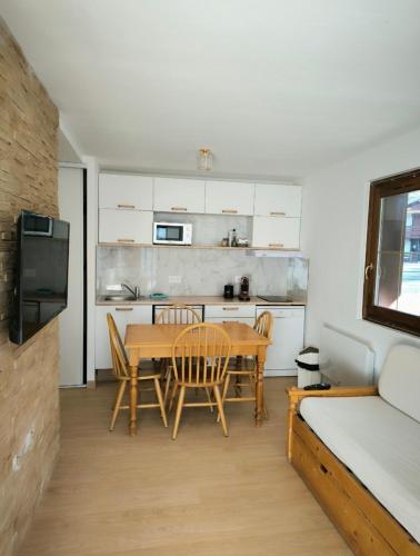 une cuisine avec une table et des chaises dans une pièce dans l'établissement Nice T2 with south facing terrace Flumet, à Flumet