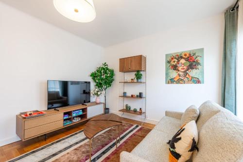 un salon avec un canapé et une télévision dans l'établissement Appart 22 T3 au centre ville, à Annecy