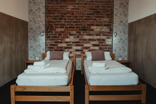two beds in a room with a brick wall at HeinrichsOase 13 - Bielefeld Mitte in Bielefeld